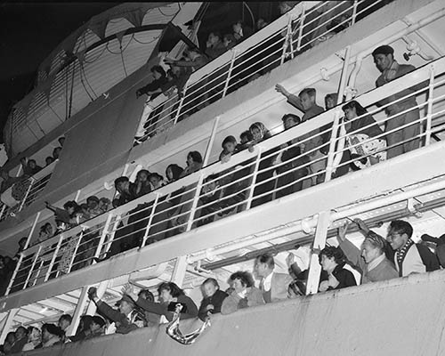 Native Dutch and native Indonesian passengers wave from the ship "Sibajak" upon arrival in the Netherlands.